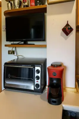 a microwave sitting on a counter next to a coffee maker at Appartamento Pepe by Sunhome Fiemme in Castello di Fiemme