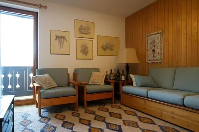 a living room with a couch and two chairs and a table at Appartamento Pepe by Sunhome Fiemme in Castello di Fiemme