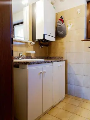 a kitchen with white cabinets and a sink at Appartamento Pepe by Sunhome Fiemme in Castello di Fiemme