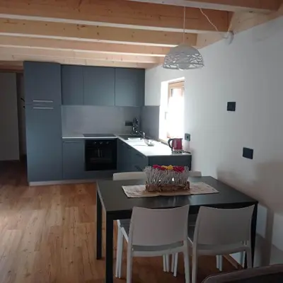 a kitchen with a table and chairs in a room at Tabia' Cemin in Predazzo