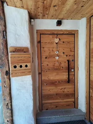a wooden door in the corner of a room at Tabia' Cemin in Predazzo
