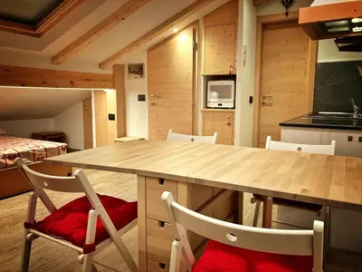 a kitchen with a large wooden table and chairs at Ad Alba di Canazei una finestra sulla Marmolada in Alba di Canazei
