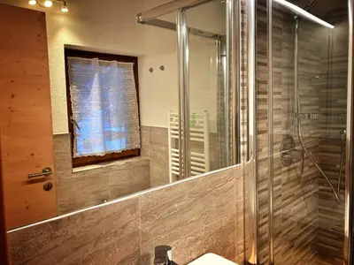 a bathroom with a shower and a sink and a mirror at Ad Alba di Canazei una finestra sulla Marmolada in Alba di Canazei
