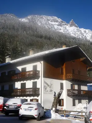 a large building with cars parked in front of it at Ad Alba di Canazei una finestra sulla Marmolada in Alba di Canazei