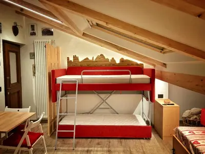a room with two bunk beds in a attic at Ad Alba di Canazei una finestra sulla Marmolada in Alba di Canazei