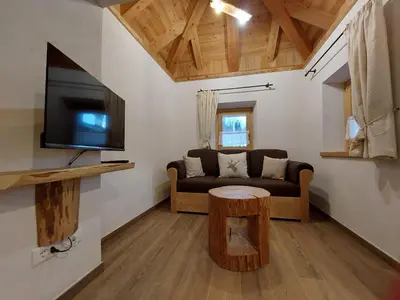 a living room with a couch and a table at LA POESIA DOLOMITI APARTMENTS in Rivamonte
