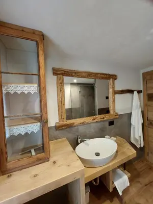 a bathroom with a sink and a mirror at LA POESIA DOLOMITI APARTMENTS in Rivamonte