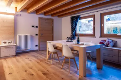 a dining room with a wooden table and chairs at Antico Borgo Palue in Sottoguda