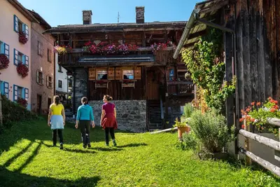 three women walking in front of a building at Antico Borgo Palue in Sottoguda