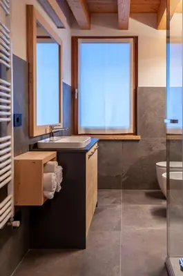 a bathroom with a sink and a toilet and a window at Antico Borgo Palue in Sottoguda