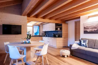 a kitchen and living room with a table and a couch at Antico Borgo Palue in Sottoguda