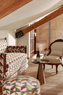 a room with a table with two chairs and a bottle of wine at Castel Sallegg Suites Adults only in Caldaro