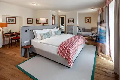 a bedroom with a bed and a living room at Castel Sallegg Suites Adults only in Caldaro