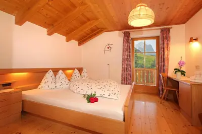 a bedroom with a bed and a window at Müllerhof in Kastelruth