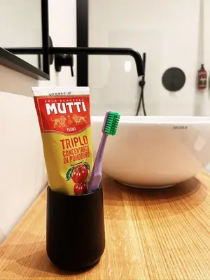 a cup of toothpaste and a toothbrush on a counter at Late Checkout Merano - 3 Zimmer, Sonnenterrasse, Garage in Merano
