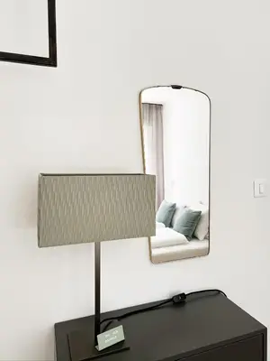 a lamp on a table in front of a mirror at Late Checkout Merano - 3 Zimmer, Sonnenterrasse, Garage in Merano