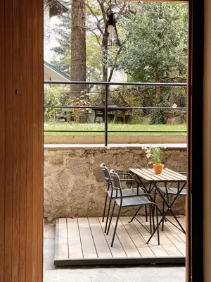 a patio with a table and chairs and a window at Late Checkout Merano - 3 Zimmer, Sonnenterrasse, Garage in Merano