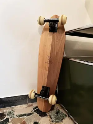 a wooden skateboard is leaning against a wall at Late Checkout Merano - 3 Zimmer, Sonnenterrasse, Garage in Merano