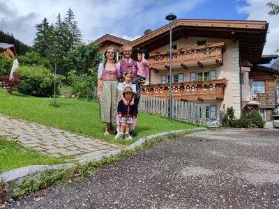 a family posing for a picture in front of a house at Appartamenti Residence Rodolon Fontanazzo in Campestrin
