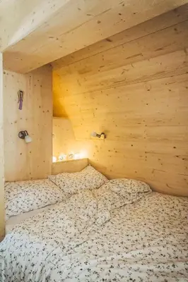 a bed in a room with a wooden ceiling at International Camping Olympia in Cortina dʼAmpezzo