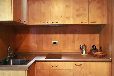 a kitchen with wooden cabinets and a sink at International Camping Olympia in Cortina dʼAmpezzo