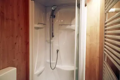 a shower in a bathroom with a glass door at International Camping Olympia in Cortina dʼAmpezzo