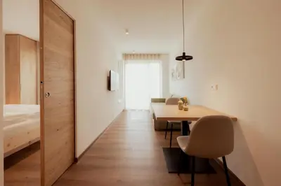 a room with a table and chairs and a bedroom at Gutshof Ebner in San Paolo
