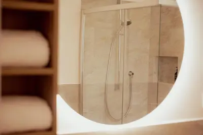 a shower in a bathroom with a mirror at Gutshof Ebner in San Paolo