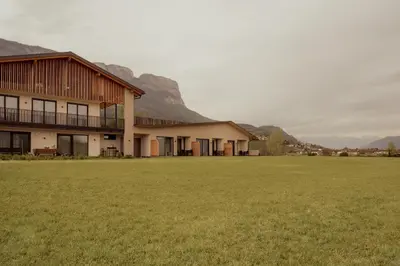 a building with a large grass field in front of it at Gutshof Ebner in San Paolo