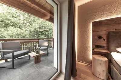 a room with a balcony with a bed and chairs at Moarhof - Apartments and moar in Varna