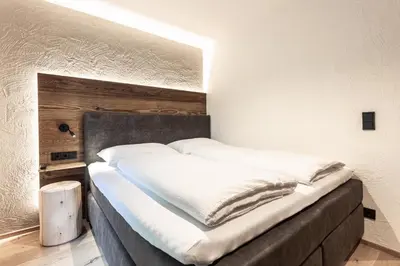 a bedroom with a large bed with white sheets at Moarhof - Apartments and moar in Varna