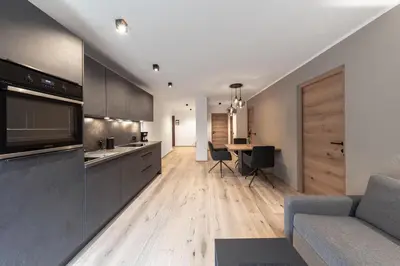 a kitchen and living room with a couch and a table at Moarhof - Apartments and moar in Varna