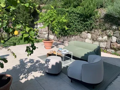 a patio with two couches and a table and chairs at Villa Tschaupp in Tirolo