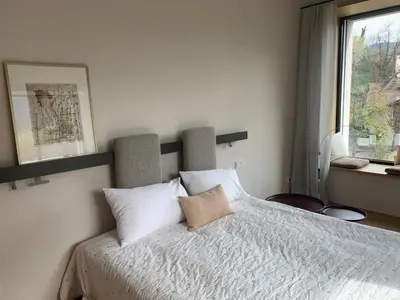 a bedroom with a bed with white sheets and a window at Villa Tschaupp in Tirolo