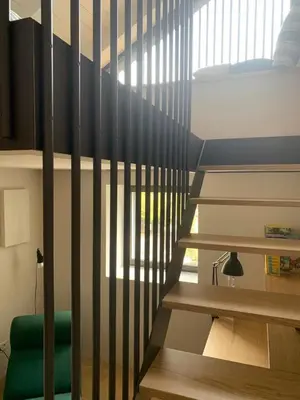 a staircase in a room with a bed and a window at Villa Tschaupp in Tirolo