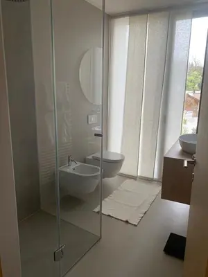a bathroom with a glass shower and a sink at Villa Tschaupp in Tirolo