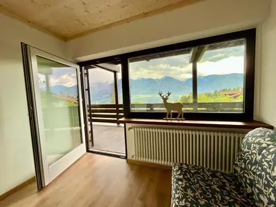 a room with a window with a deer statue in it at Mountain Chalet Tre Marie in Cavalese