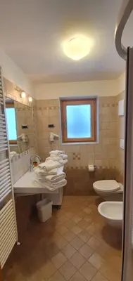 a bathroom with two sinks and a toilet and a window at Appartamento da Meto in San Martino di Castrozza