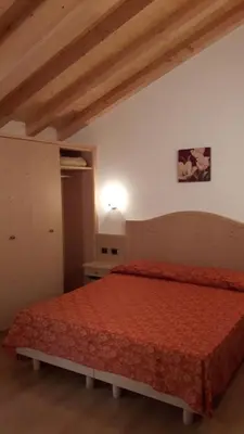 a bedroom with a bed with a red bedspread at Appartamento da Meto in San Martino di Castrozza