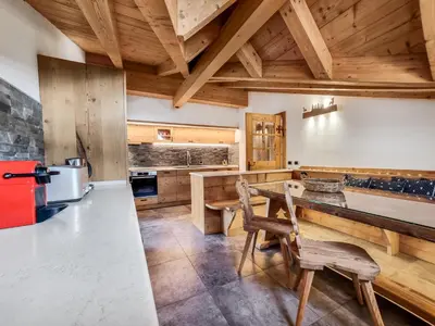 a kitchen with wooden ceilings and a table and chairs at Casa Panoràma in the heart of the Dolomites, Moena in Moena