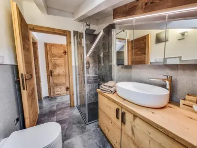 a bathroom with a sink and a glass shower at Casa Panoràma in the heart of the Dolomites, Moena in Moena