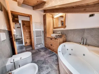 a bathroom with a tub and a toilet and a sink at Casa Panoràma in the heart of the Dolomites, Moena in Moena