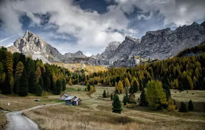 a house in a field with mountains in the background at Casa Panoràma in the heart of the Dolomites, Moena in Moena
