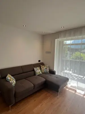 a living room with a brown couch and a window at Ciasa Valiares in San Vigilio Di Marebbe