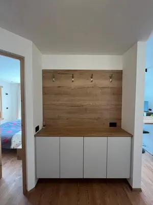 a bedroom with white cabinets and a wooden wall at Ciasa Valiares in San Vigilio Di Marebbe
