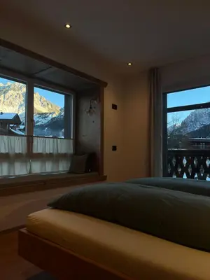 a bedroom with a bed and a window with a mountain view at Ciasa Valiares in San Vigilio Di Marebbe