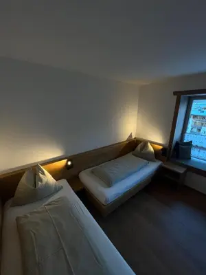 a hotel room with two beds and a window at Ciasa Valiares in San Vigilio Di Marebbe