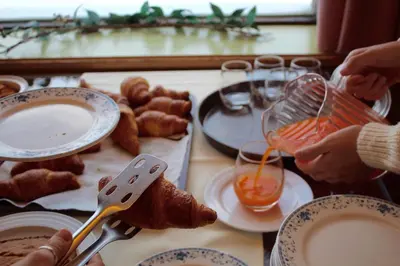 a table topped with plates of food with people holding spoons at Albergo Venezia in Passo Rolle