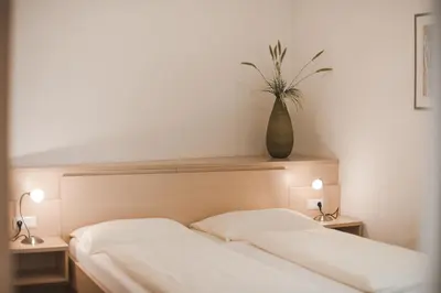a bedroom with a bed with a vase on top of it at Ansitz Rynnhof in Termeno
