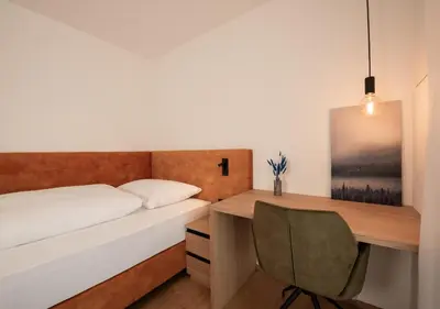 a bedroom with a desk and a bed and a chair at Luxury Penthouse - Between Kronplatz, 3 Peaks Dolomites and Lake Prags in Monguelfo